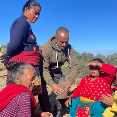 A group of people outside working together to utilize commercial farming practices such as chemical fertilizer use