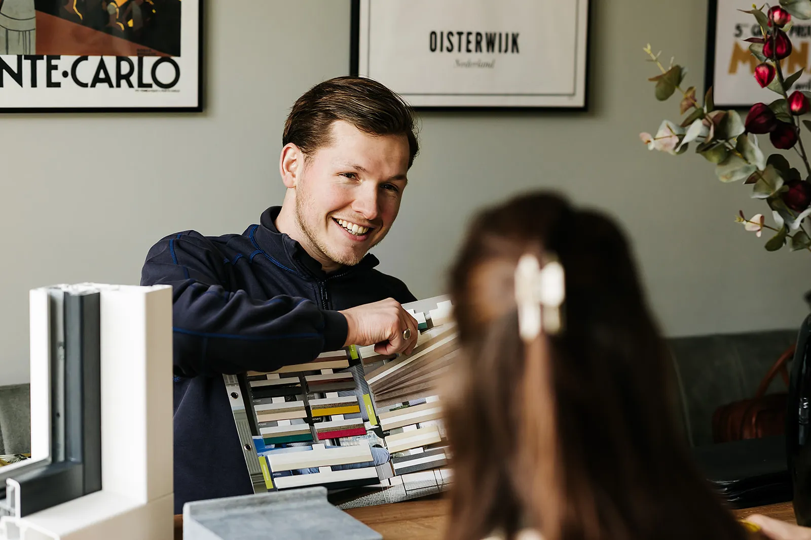 Kupro-adviseur toont kleurstalen aan een klant aan de keukentafel