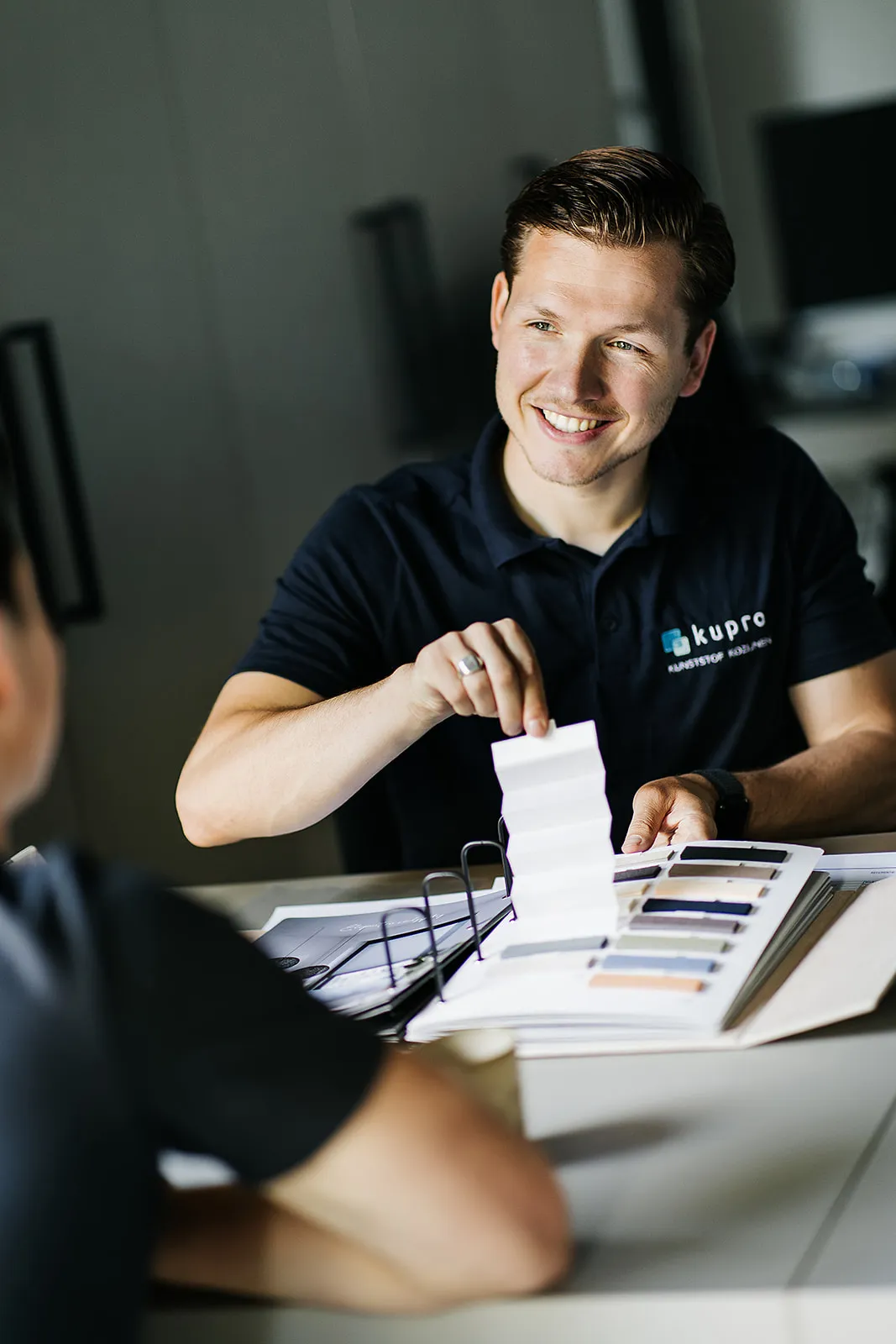 Kupro-adviseur laat kleurstalen voor kozijnen zien tijdens een adviesgesprek