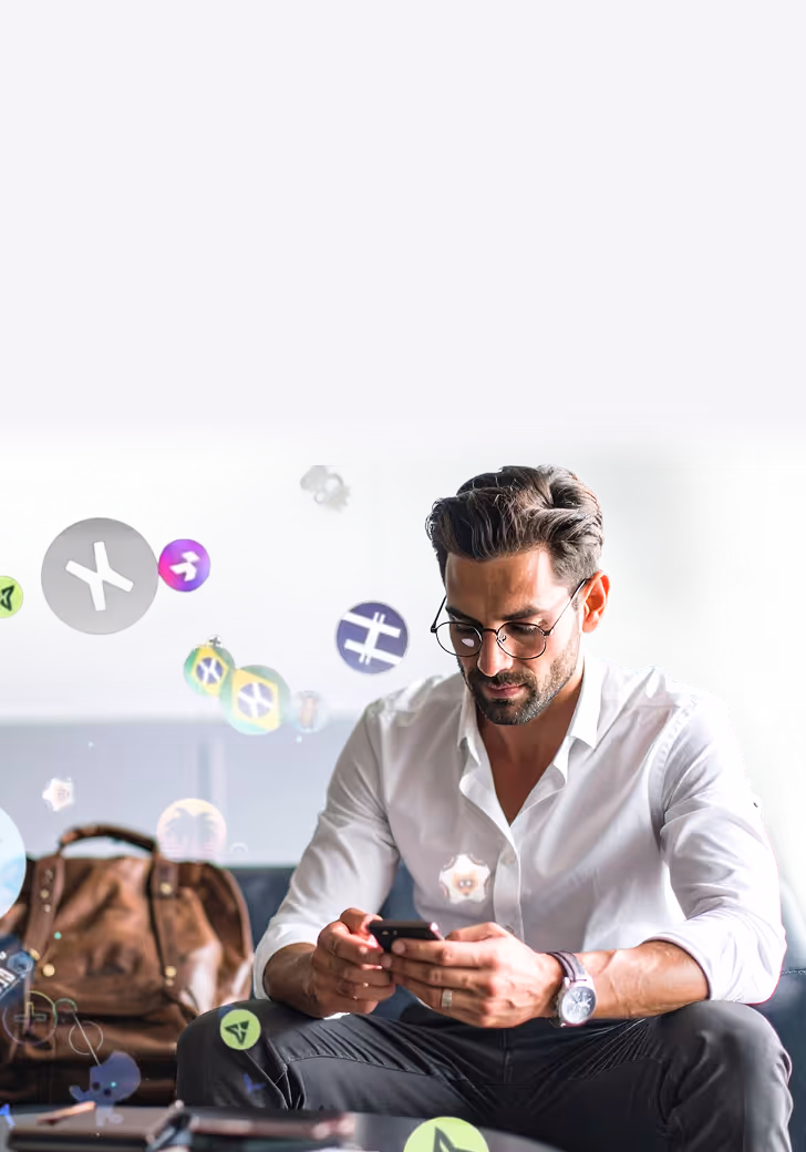 Man wearing glasses and a white shirt sitting on a sofa, focused on his smartphone with a brown leather bag in the background and floating digital icons around him.