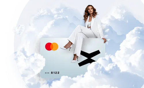 Woman dressed in white sitting on a large credit card with Mastercard logo, surrounded by fluffy clouds.