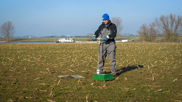 Man op het land voert een handboring uit
