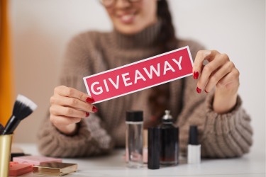 Woman holding a sign that says Giveaway