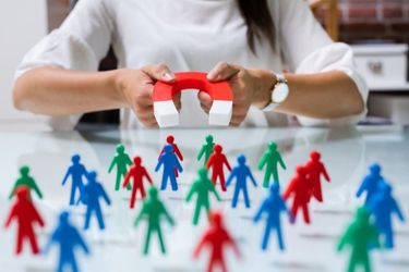 Woman holding a magnet attracting people
