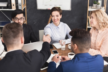 two people shaking hands in a group of people
