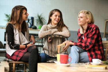 three woman chit chatting over coffee