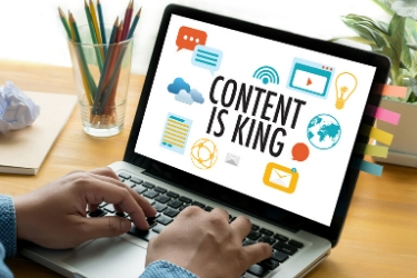 Man using a laptop showing a graphic that says "Content is King".