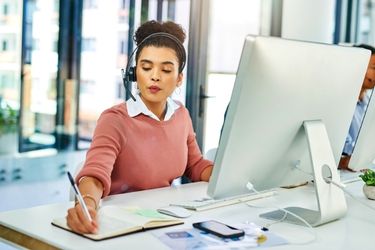 Woman making follow up calls and taking notes