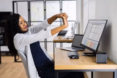 Woman stretching at her working station
