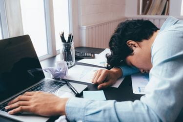 Man sleeping in front of his laptop