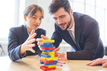 Team building - coworkers playing tumbling wooden blocks