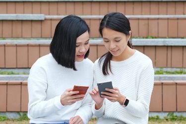 Woman showing something from her phone to another person