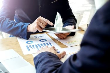 Man discussing marketing data and using a tablet