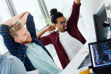 6 maneiras de reduzir as reivindicações de acidentes de trabalho e aumentar os lucros 4 Funcionários se esticando em frente ao computador