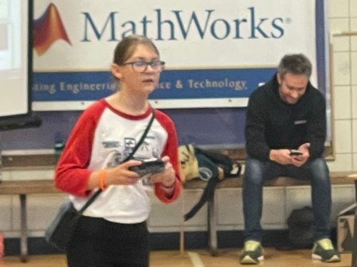 A man and a woman standing in front of a sign