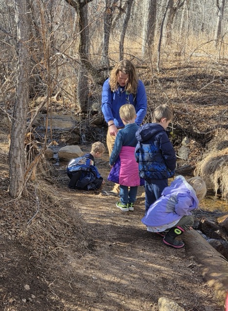 An AcademyACL family volunteer exploring outdoors with students
