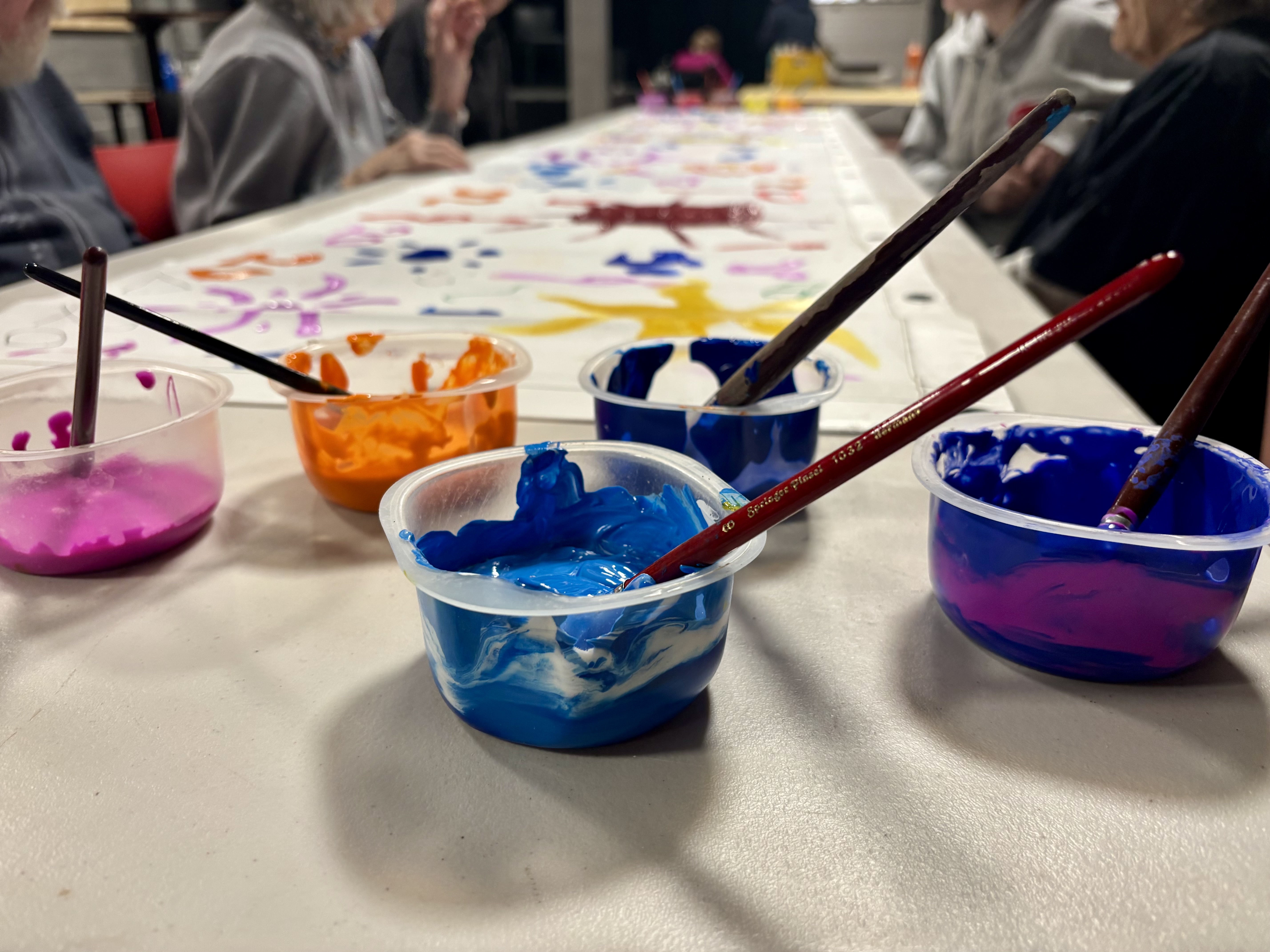 a fresco and pots of paint with brushes and markers