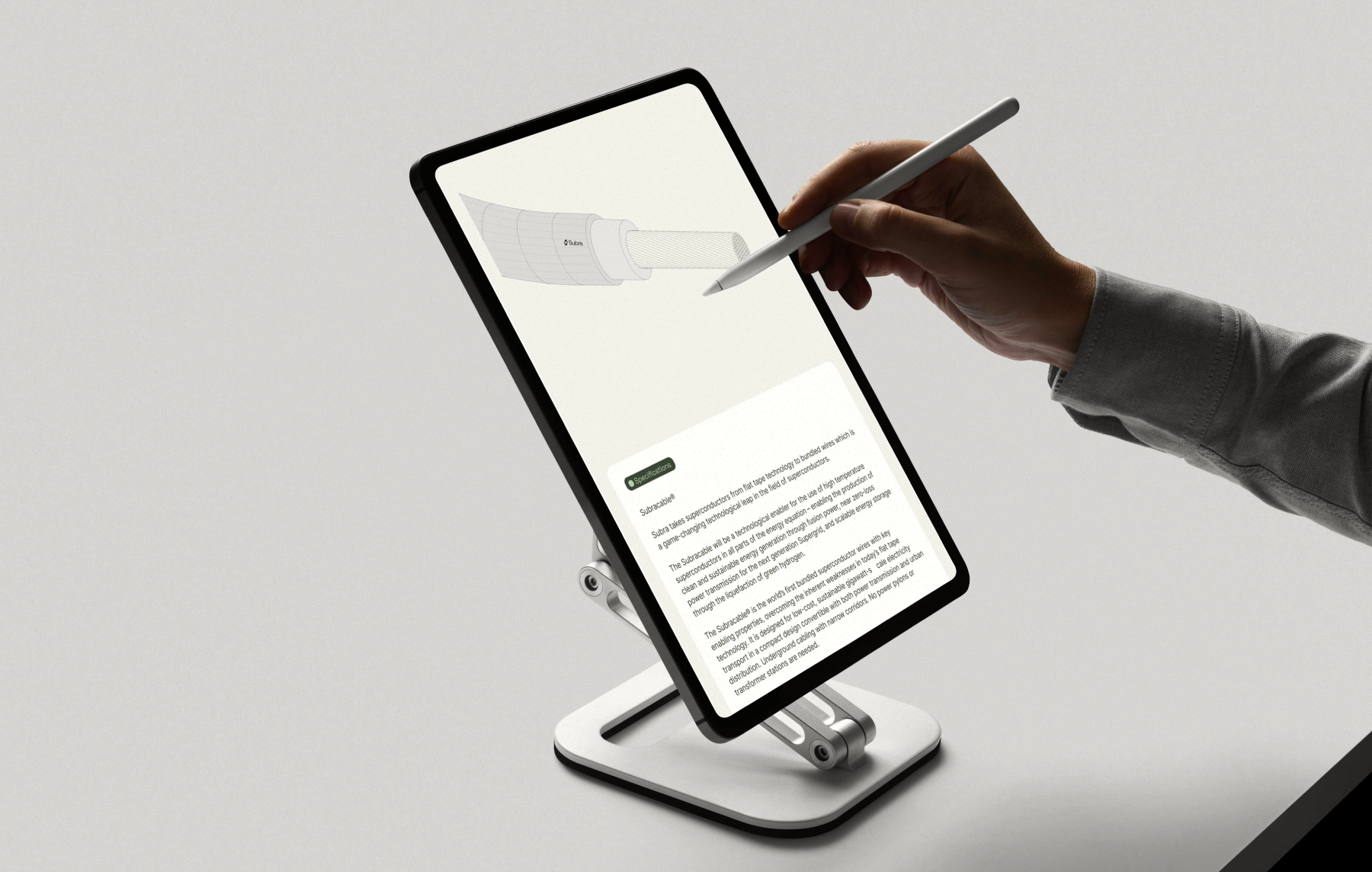 Hand using a stylus to interact with a tablet displaying technical specifications and a wire diagram on a white adjustable stand.