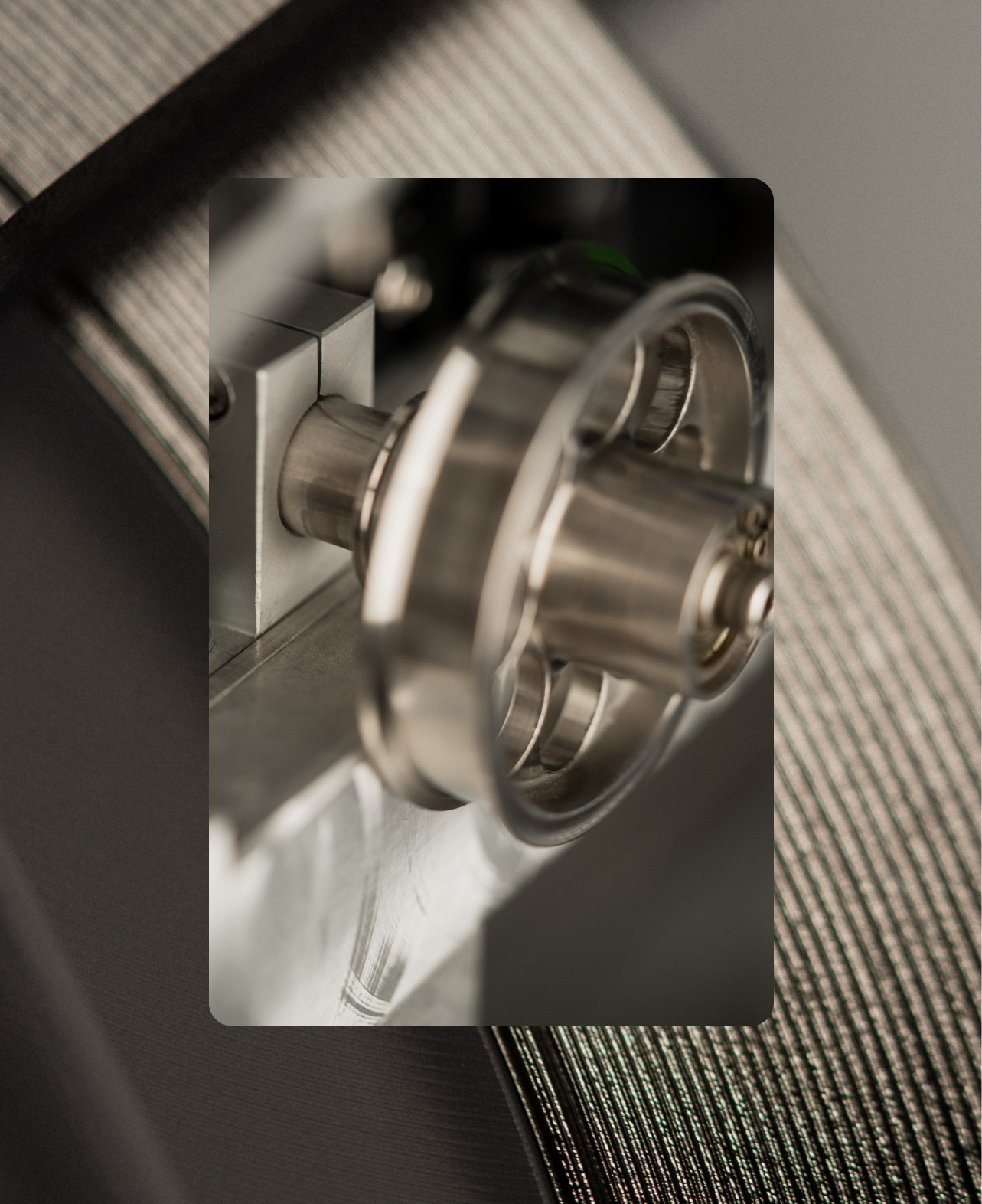 Close-up of a shiny metallic industrial wheel or pulley attached to machinery.