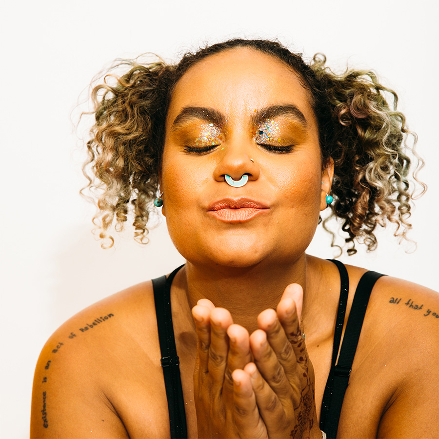 adrienne maree brown with eyes closed blowing a kiss to the camera