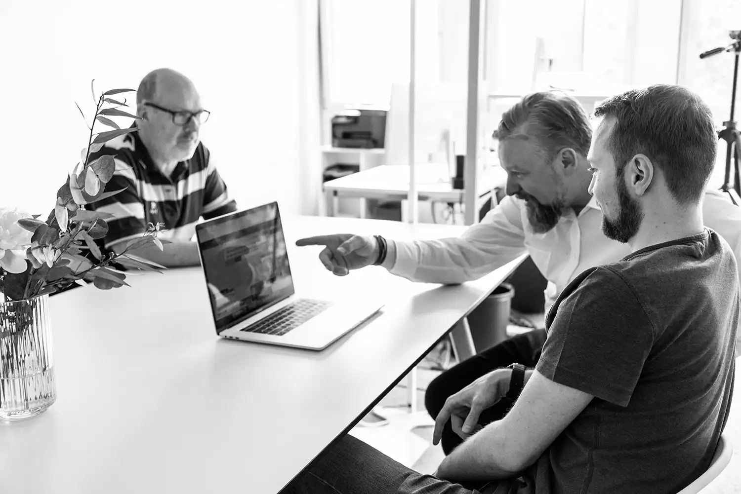 Drei CROWDCODE Kollegen halten eine Besprechung am Laptop