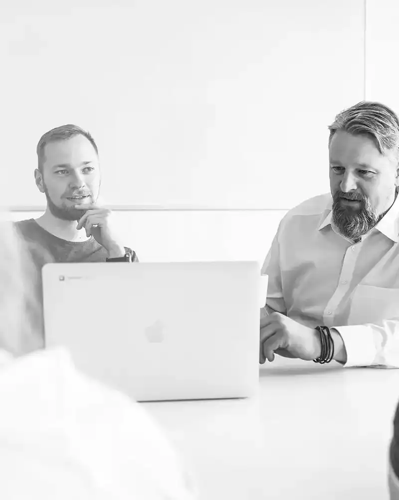 CROWDCODE ArbeitskollegInnen sitzen zusammen am Tisch und besprechen etwas 