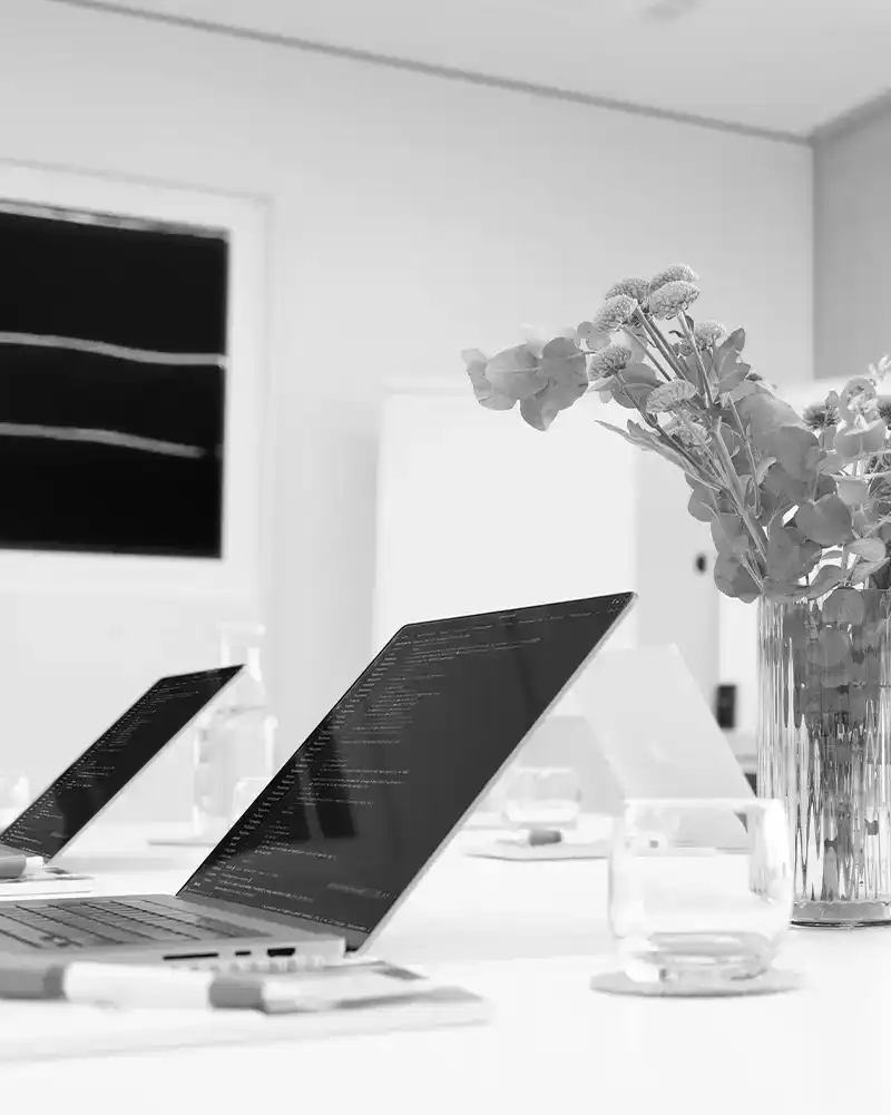 Seminarraum ausgestattet mit Laptops und Schreibutensilien.