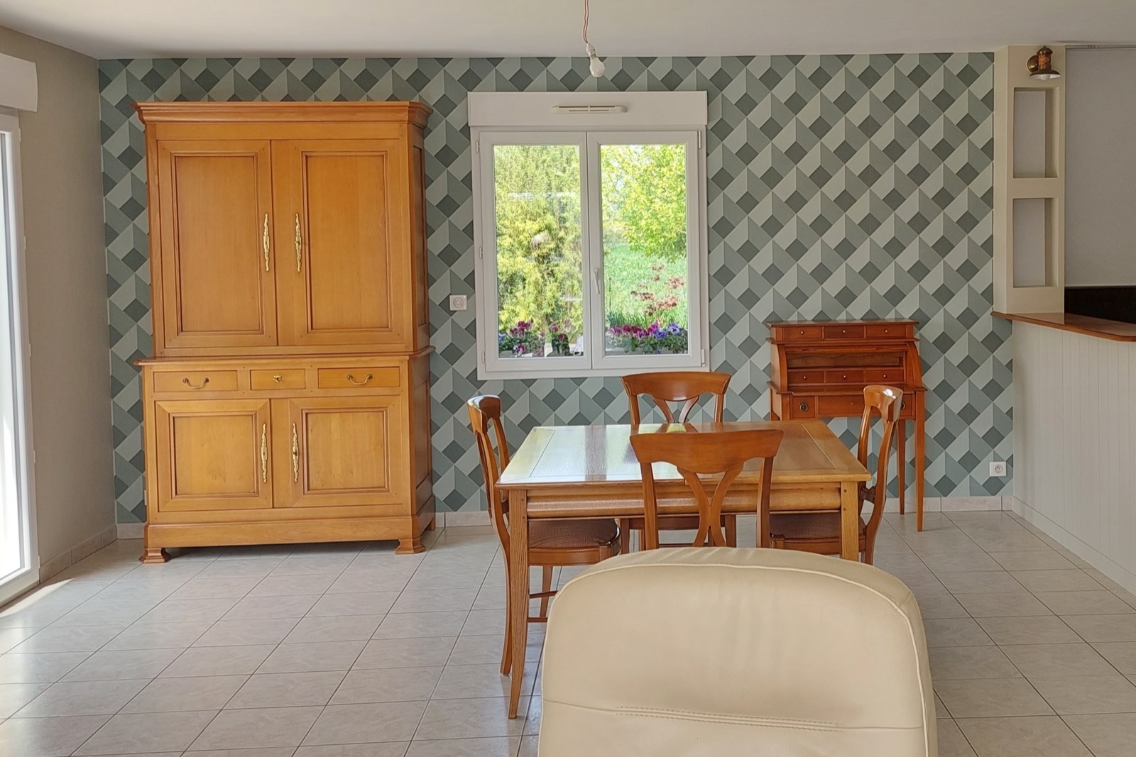 Salle à manger avec papier peint à motif de cubes en trompe-l'œil derrière la table