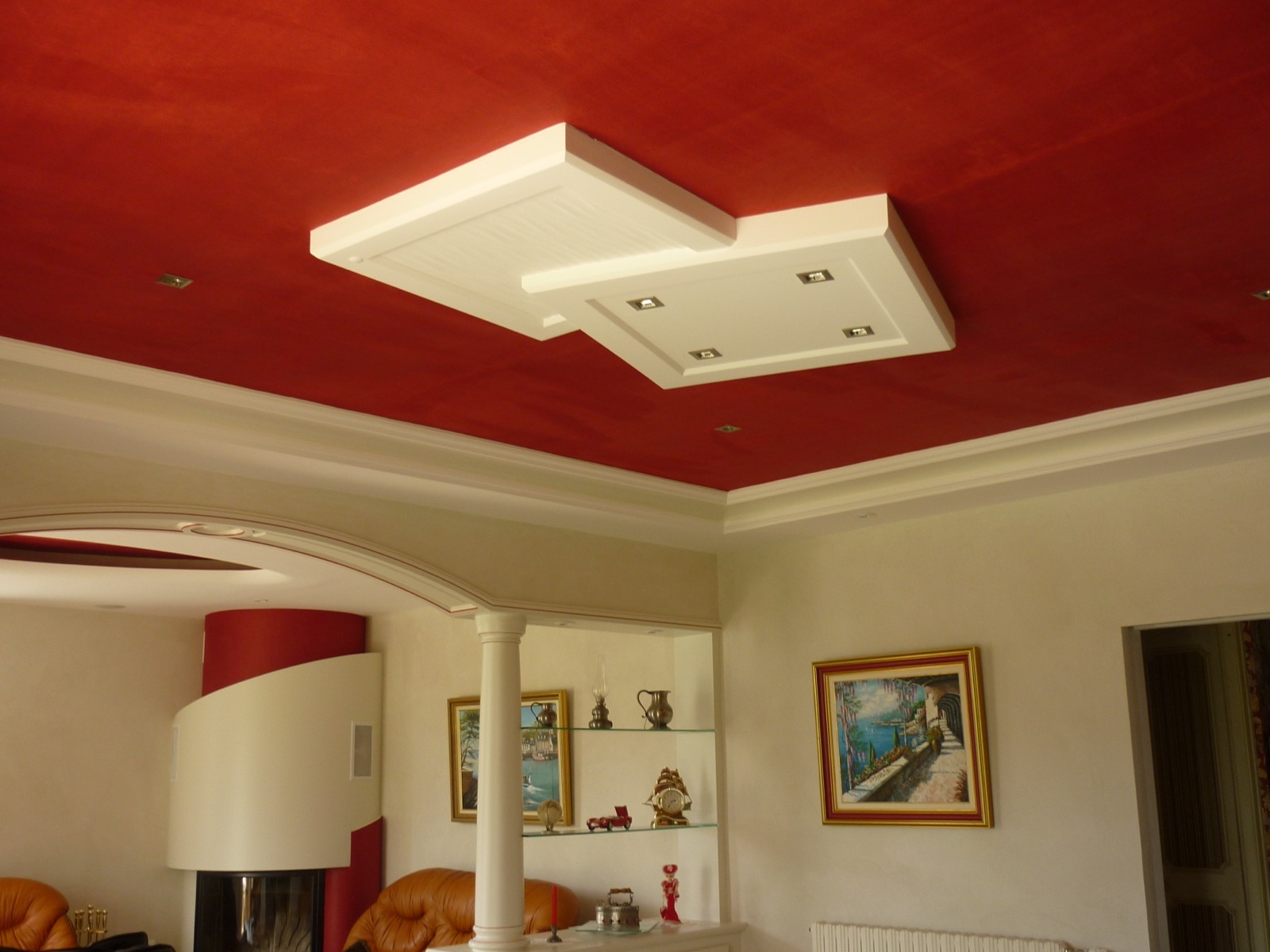 Caissons en staff blancs superposés avec spots encastrés sur un plafond peint en rouge