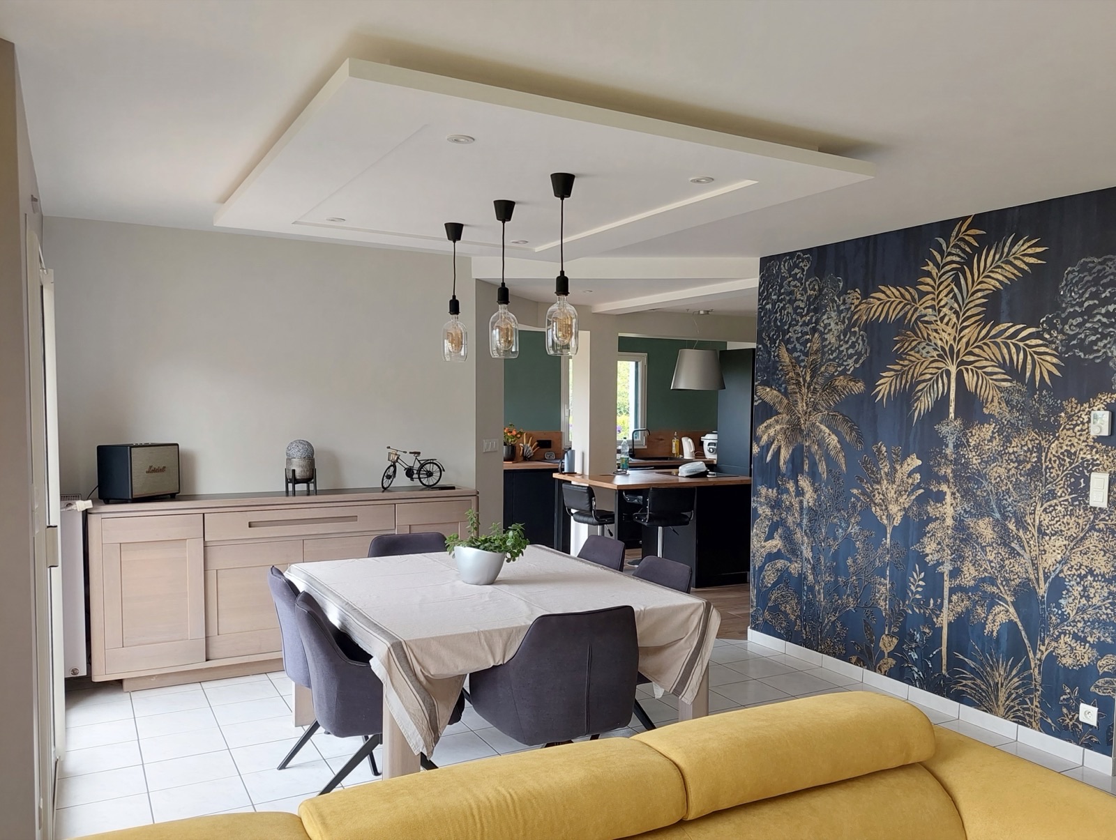 Caisson en staff au-dessus d'une table, papier peint panoramique à palmiers dorés sur fond bleu nuit