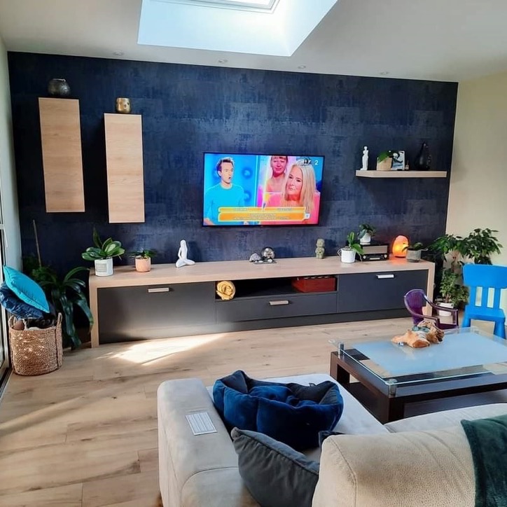Salon avec un mur d'accent bleu nuit à effet matière et sol effet bois clair