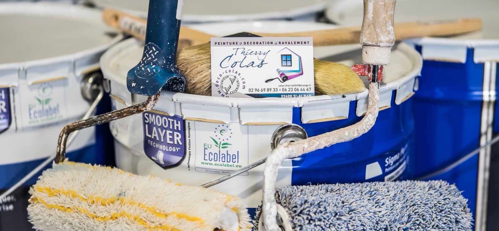 Pots de peinture portant le logo Ecolabel, rouleaux et carte de visite Thierry Colas