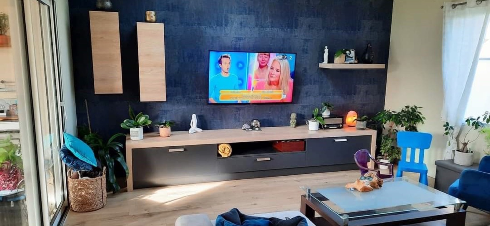 Salon avec un mur d'accent bleu nuit à effet matière et sol effet bois clair