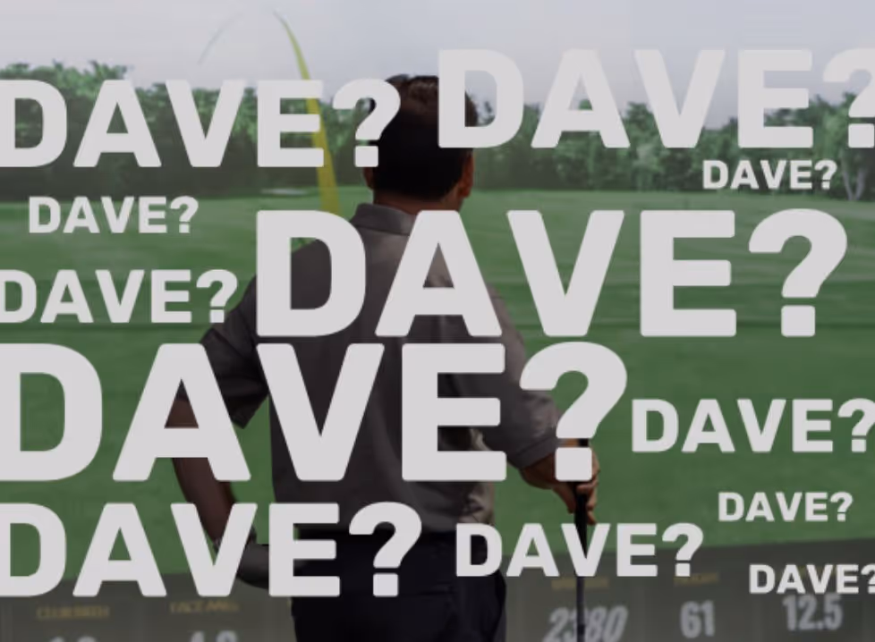 Two men playing golf at the GolfCave. One man is over the ball about to hit while the other watches
