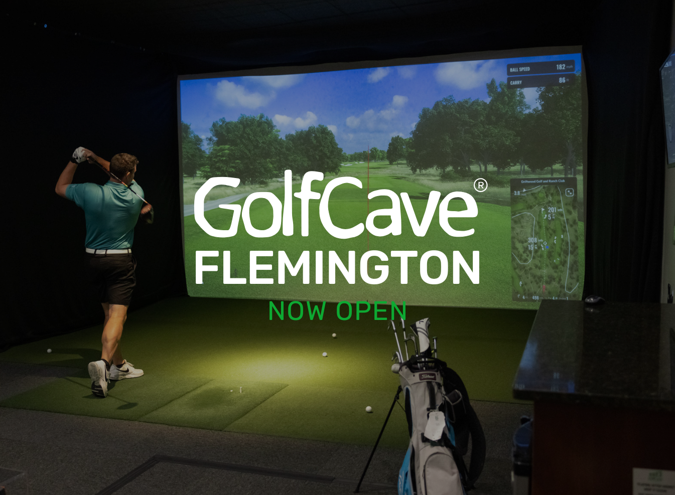 Two men playing golf at the GolfCave. One man is over the ball about to hit while the other watches