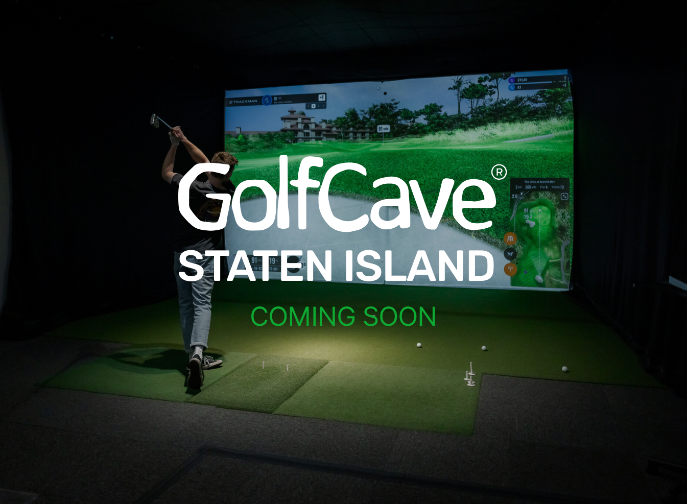 Two men playing golf at the GolfCave. One man is over the ball about to hit while the other watches