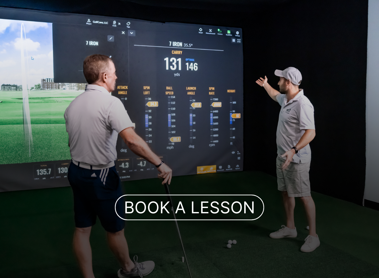 Two men playing golf at the GolfCave. One man is over the ball about to hit while the other watches