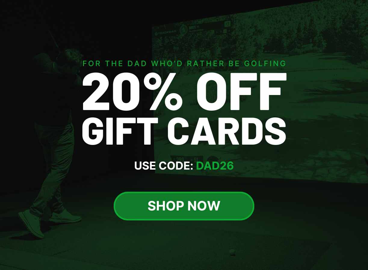 Two men playing golf at the GolfCave. One man is over the ball about to hit while the other watches