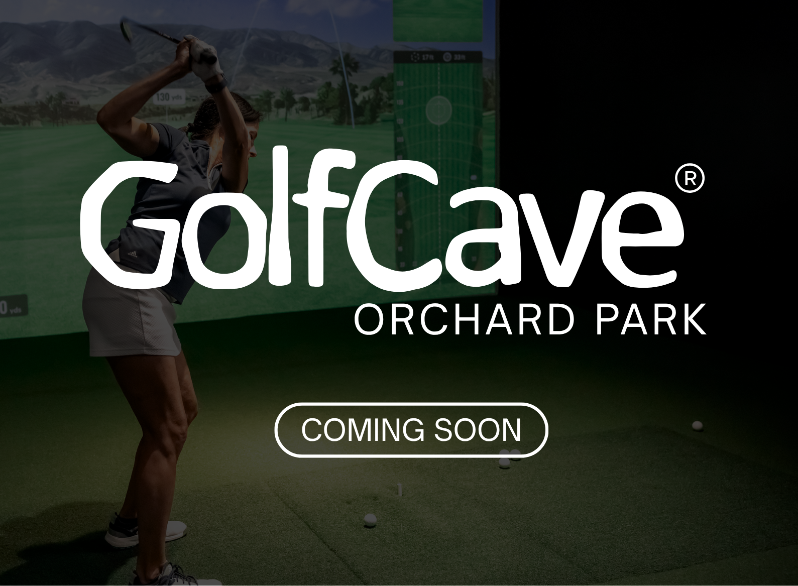 Two men playing golf at the GolfCave. One man is over the ball about to hit while the other watches