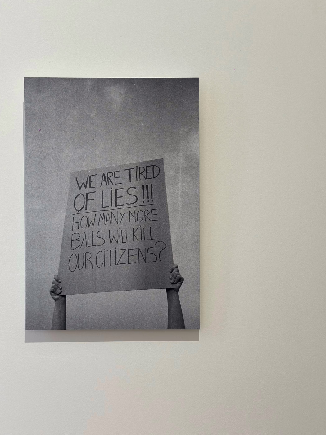 Černobílá fotografie rukou držících ceduli s nápisem We are tired of lies!!!