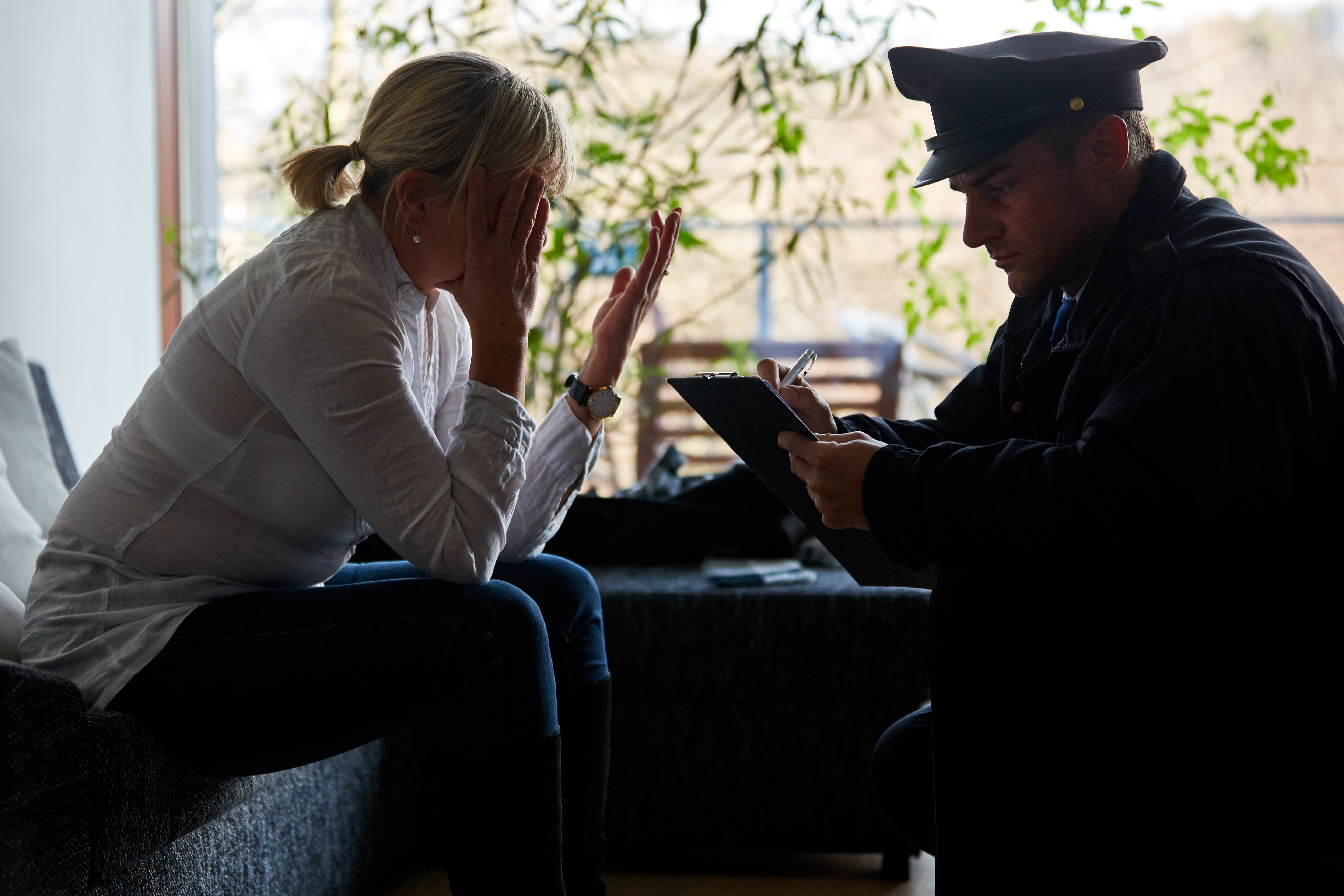Woman crying to police officer after her home was robbed