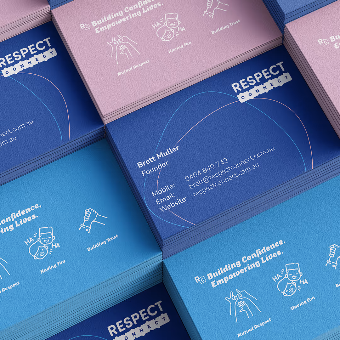 Stacks of Respect Connect business cards in blue and pink featuring founder Brett Muller's contact details and phrases promoting mutual respect, fun, and trust.