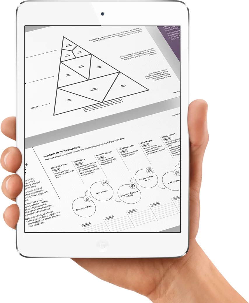 Hand holding a tablet showing a black-and-white branded template with a triangular framework and hero's journey story map.