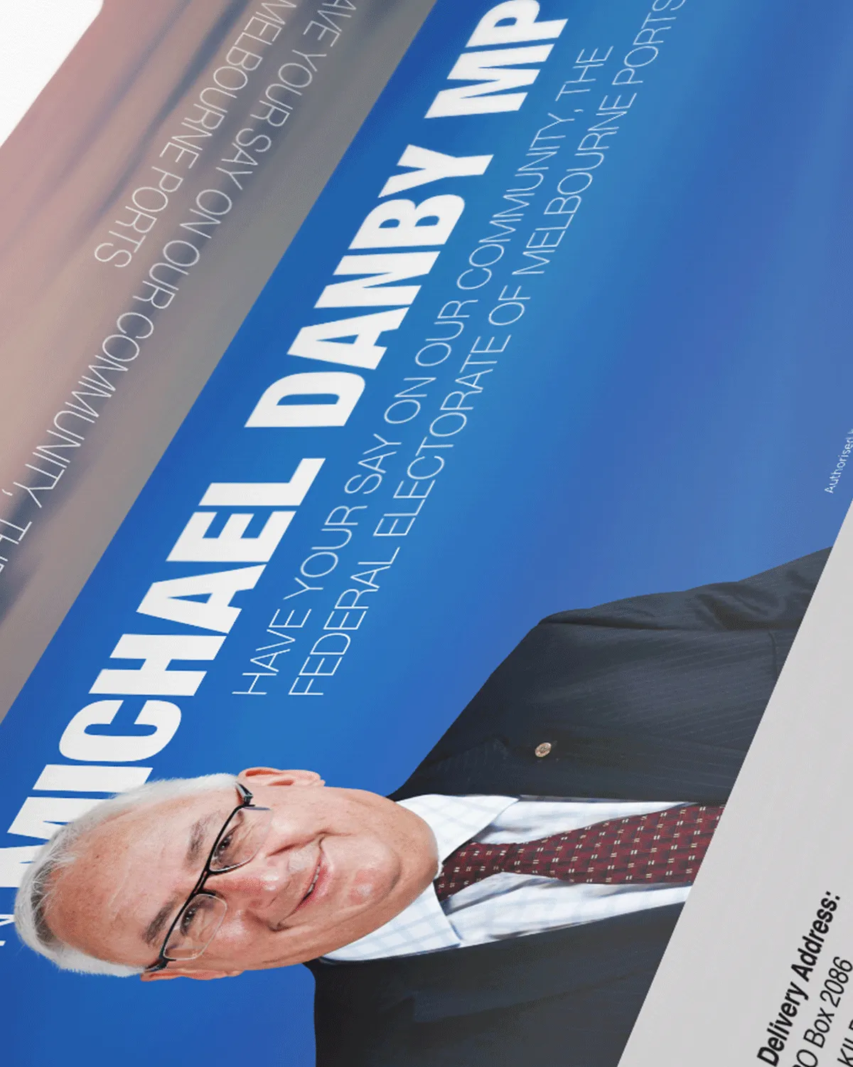 Portrait of man in suit and glasses with blue background and text about Michael Danby MP.