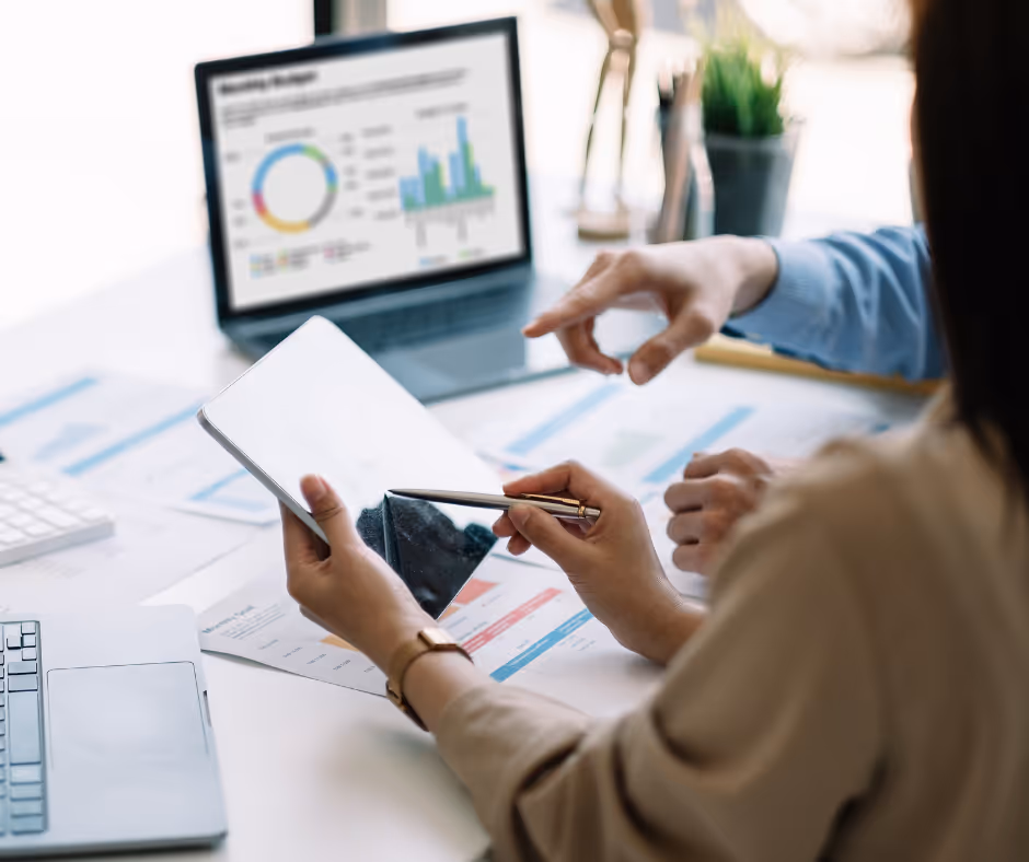 Accountant with a client at a desk using a tablet, showing success from SEO for Accountants.