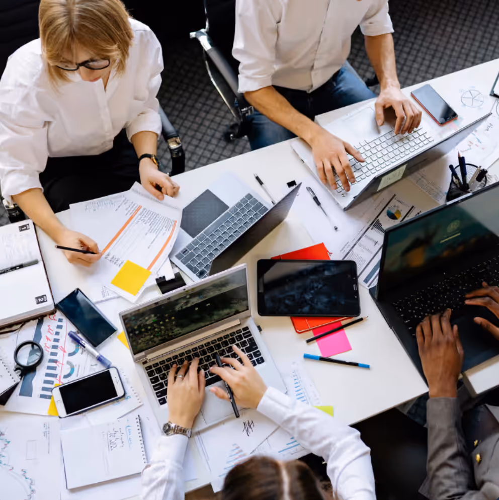 Insurance brokers surrounded by paperwork at a desk, handling the surge of business from SEO for Insurance Brokers.