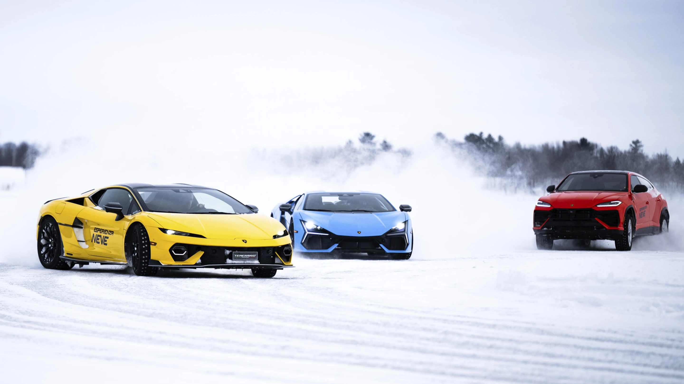 Lamborghini vehicles driving across an icy track with snow trails behind, showcasing performance during the winter experience