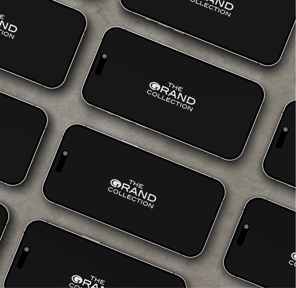Multiple smartphones arranged with The Grand Collection branding on screen, reinforcing a cohesive digital identity