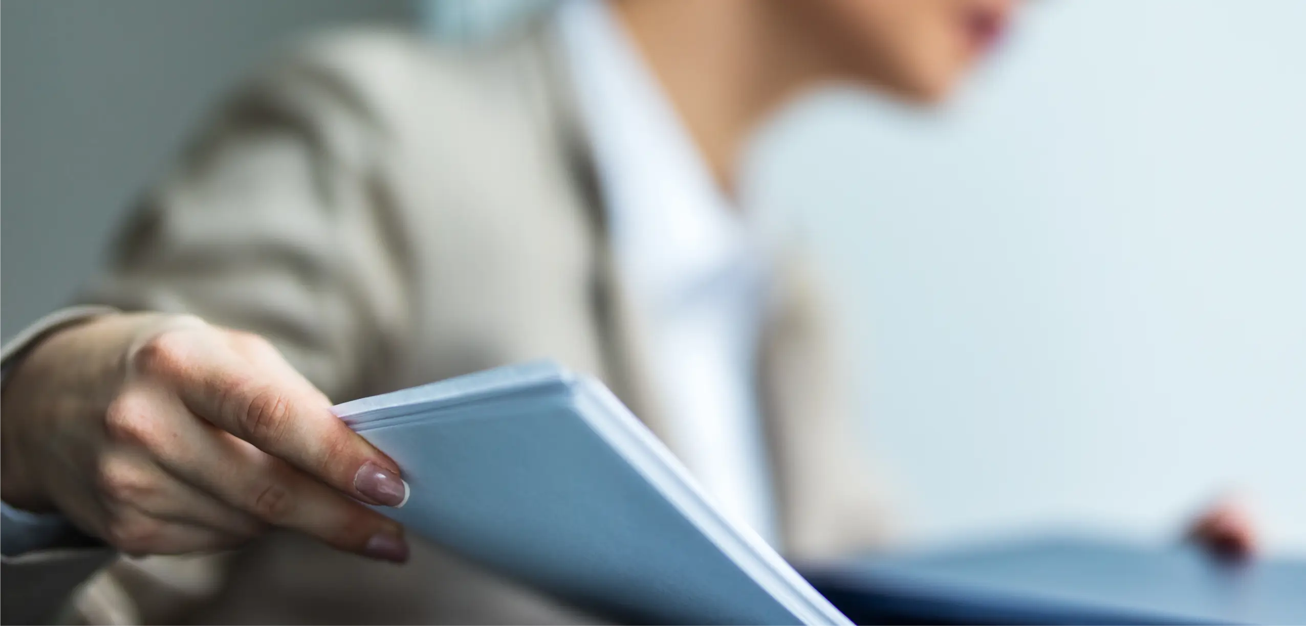 Businessperson handing over printed documents, representing Canon’s focus on professional print quality and seamless document sharing in small offices.