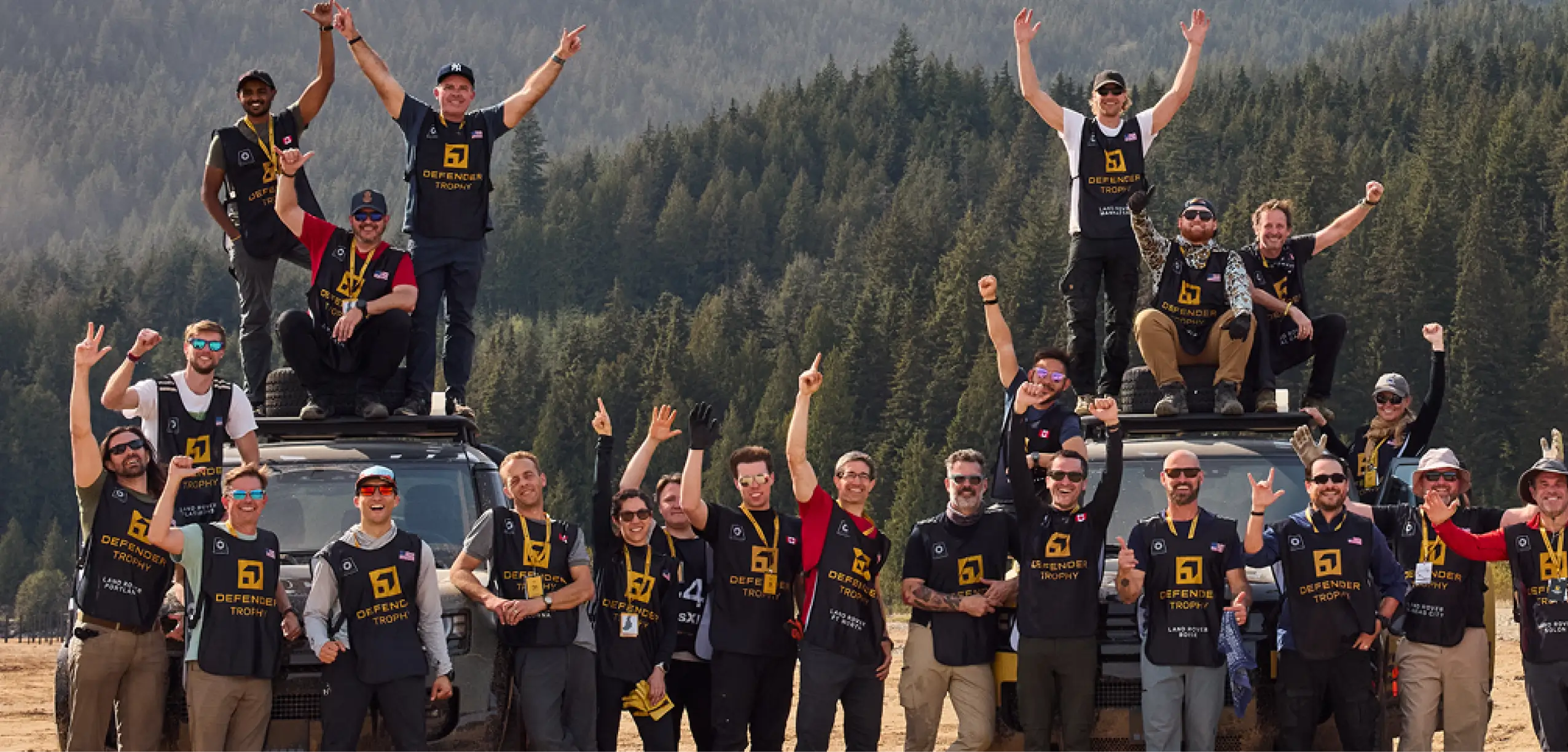 Defender Trophy competitors gather on Defender vehicles during the North American Market Selection Event, celebrating advancement toward the Global Finals.